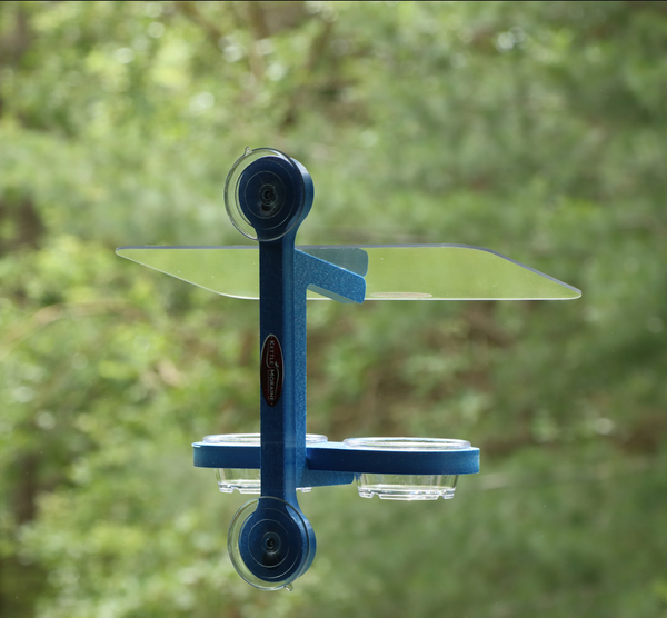 Blue recycled plastic bird feeder is window mounted with suction cups. Holds two clear plastic cups. Clear roof. 